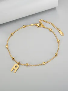 Close-up of 18K gold plated titanium steel beaded anklet featuring a letter R charm