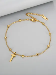 Close-up detail of a minimalist 18K gold plated beaded anklet with a cross pendant