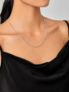 Detailweergave van een minimalistische titaniumstalen vossenstaartketting op de hals