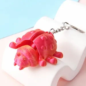 Gedetailleerd uitzicht van een 3D-geprinte rode gearticuleerde insecten sleutelhanger.