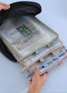Λεπτομερής άποψη διχτυωτών φακέλων για σχολικά μαθήματα που βγαίνουν από μαύρο σακίδιο.