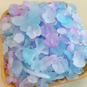 Vista dettagliata di ciondoli in resina con farfalle e rose smerigliate miste in blu pastello.