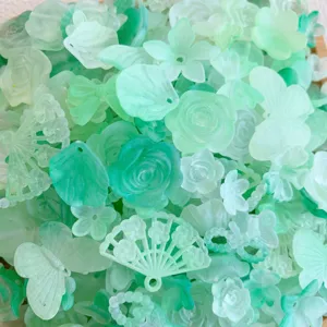 Primo piano dettagliato di ciondoli smerigliati verdi misti per decorazioni e hobbistica.