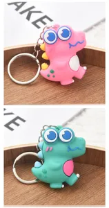 Gros plan de mignon porte-clés dinosaure dessin animé en silicone pour clés de voiture sacs.