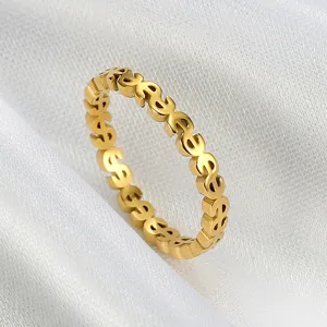 Close-up of gold stainless steel ring featuring a recurring dollar sign pattern design.