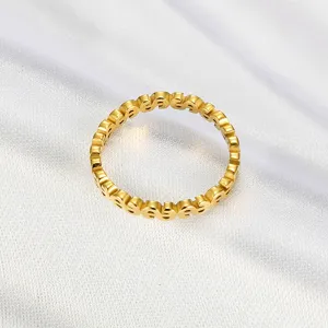 Macro view of gold-plated titanium steel ring featuring creative dollar sign cutouts
