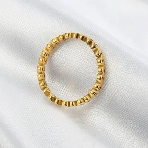Close-up of a gold-plated titanium steel ring featuring a repeating dollar sign design