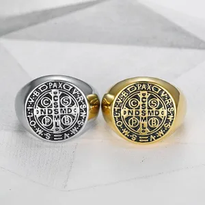Close-up of vintage stainless steel signet rings with detailed religious engraving
