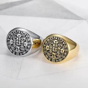 Close-up of vintage St. Benedict stainless steel signet rings in gold and silver