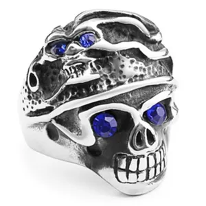 Dettaglio di un anello teschio vintage in acciaio inossidabile con occhi in strass blu