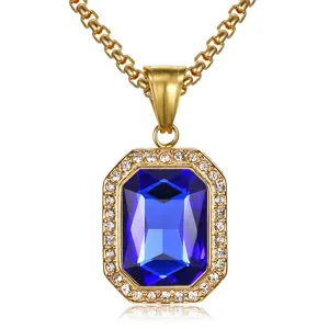 Close-up detail of a golden necklace with a large blue emerald-cut gemstone and crystal halo