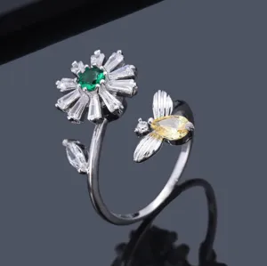 Detailansicht eines verstellbaren Rings mit Gänseblümchen, Biene und bunten Kristallen.