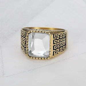 Nahaufnahme eines Herrenrings mit quadratischem Edelstein und goldenem Meander-Muster.