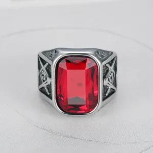 Macro view of men's titanium steel ring with large rectangular red gemstone and Masonic engraving