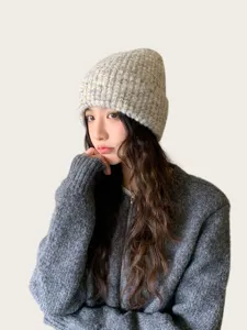 Close-up detail of the cozy wool blend speckled knit beanie hat worn by model for warmth.