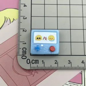 Detailansicht des Harz-Spielkonsolen-Charms mit süßem gelben Küken für DIY-Handyhüllen.