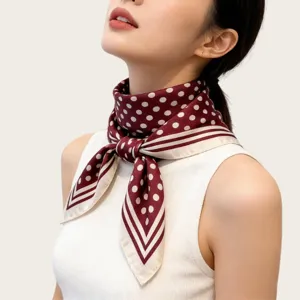 Close-up of elegant burgundy polka dot silk scarf, vintage Hepburn style neckerchief detail.