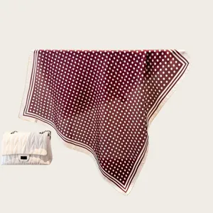 Close-up detail view of a retro polka dot square silk scarf, ideal for styling shirts or bags.