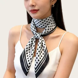 Close-up detail of a classic black and white polka dot silk scarf tied elegantly on neck.