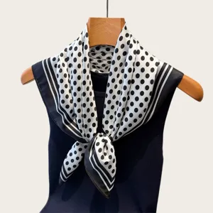 Close-up detail of the elegant black and white polka dot square silk scarf for women.