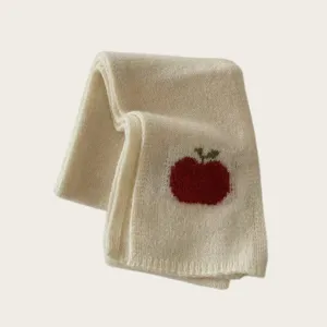 Knit scarf detail featuring a cute red apple pattern, warm winter accessory for women.