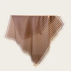 Detailed view of brown polka dot square scarf, soft fabric texture with elegant border.