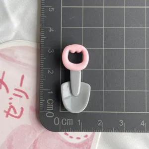 Resin shovel craft accessory detail view, cute pink cat head handle for DIY phone case decor.