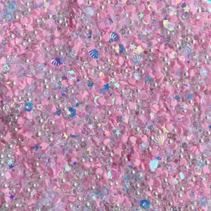 Coeurs en argile rose et paillettes de perles macro détail pour décoration artisanale.