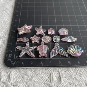 Breloques en résine océan rose irisé translucide assorties étoiles et coquillages