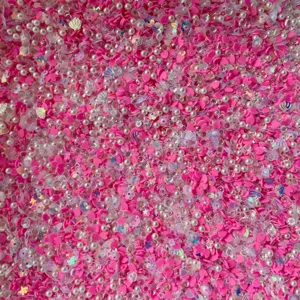 Gros plan détaillé de cœurs en argile polymère rose, de perles et de sequins pour loisirs.
