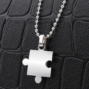 Collana con ciondolo a forma di puzzle in acciaio inossidabile su sfondo nero testurizzato