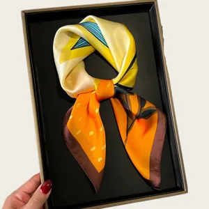 Elegant silk square scarf with vibrant yellow and orange geometric patterns for women.