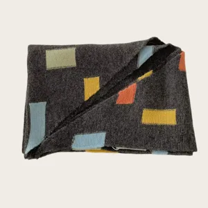 Close-up detail of women's cozy knit scarf with colorful geometric block patterns.