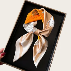 Detail view of elegant satin small square silk scarf with floral line art in chic orange tone.