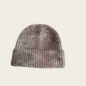 Close-up detail of the woolen mixed color ribbed knit beanie hat, showcasing cozy winter texture.