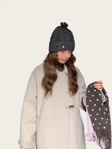 Detailansicht einer grauen Strickmütze im koreanischen Stil mit süßer Schleife für den Winter.