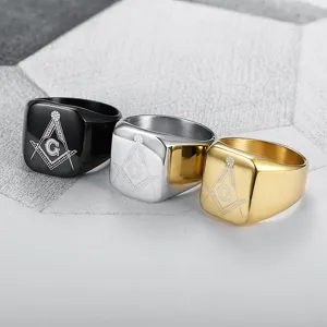 Dettaglio di tre anelli con sigillo massonico da uomo in acciaio inossidabile oro, argento e nero.