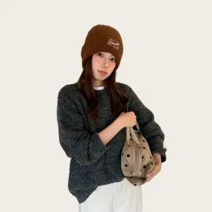 Detailed view of the winter warm brown knit beanie hat, thick thermal wool cap for women.