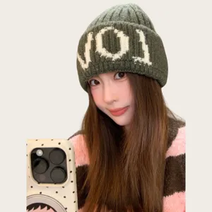 Confortable bonnet en tricot douillet avec des détails de lettres tricotées pour l'hiver.