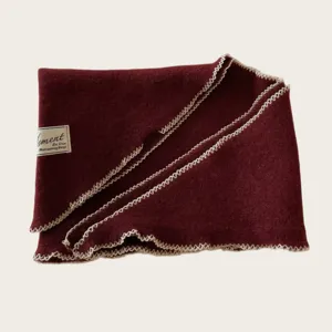 Gemütliches Wollstrick-Dreiecktuch mit kontrastierender Ziernaht für warme Tage.