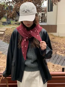 Vista detallada del pañuelo triangular de punto con patrón floral para un estilo de invierno cálido.