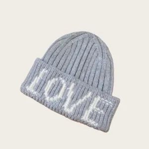 Détail de bonnet en tricot gris montrant la broderie de lettres LOVE blanches texture gros plan