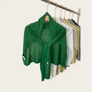 Detailed view of lightweight summer knitted shawl, soft hollow-out fabric, elegant drape design.