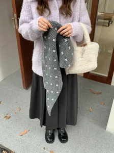 Detalle de la bufanda triangular de punto de lana cálida con bonito patrón floral para invierno.