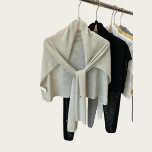 Detailed view of lightweight knitted women shawl, soft solid color scarf drape texture.