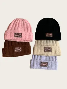 Detailed view of cozy knitted beanies in multi-colors with patch, thick warm winter headwear.