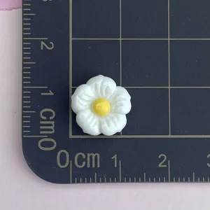 Mini white and yellow resin flower detail shot, perfect for nail art and DIY craft decor.