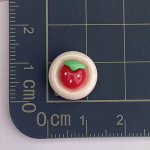 Resin strawberry cabochon detail shot, mini nail art charm and DIY crafting accessory.