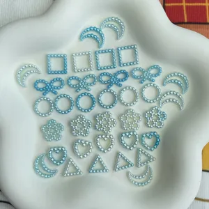 Detail shot of blue gradient ABS pearl charms, various shapes like bows and flowers.