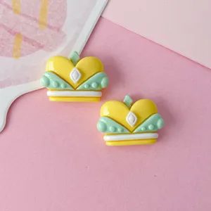 Glossy yellow green crown resin cabochons close up, perfect for DIY crafts and hair clips.